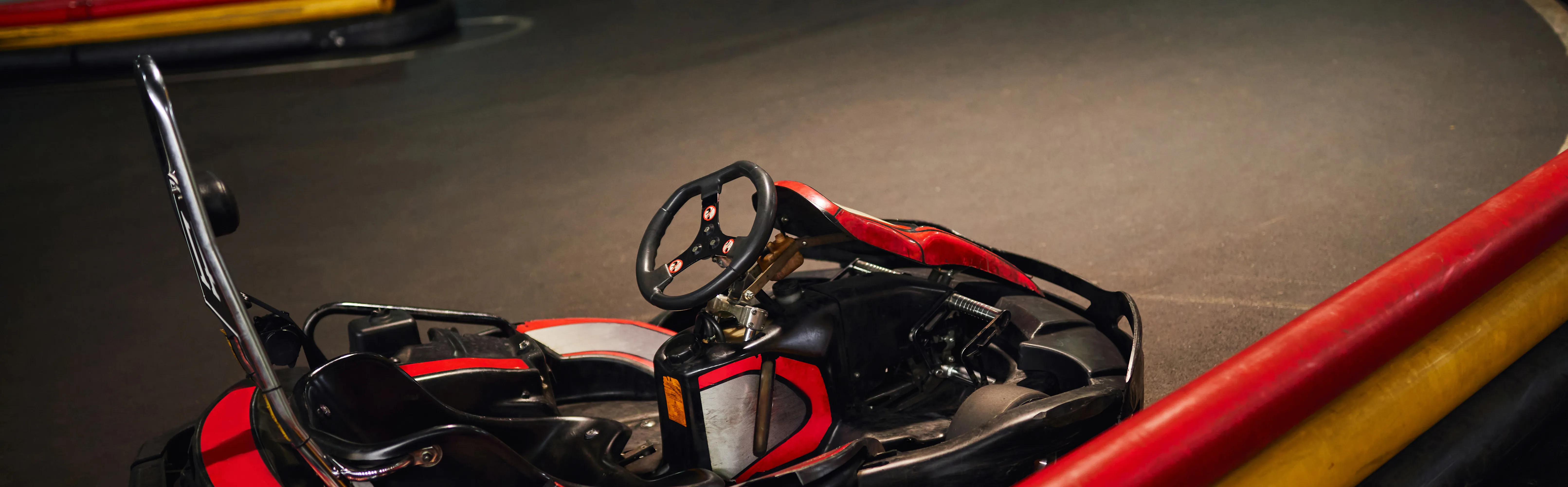Kart contornando uma curva com barreiras vermelhas e amarelas